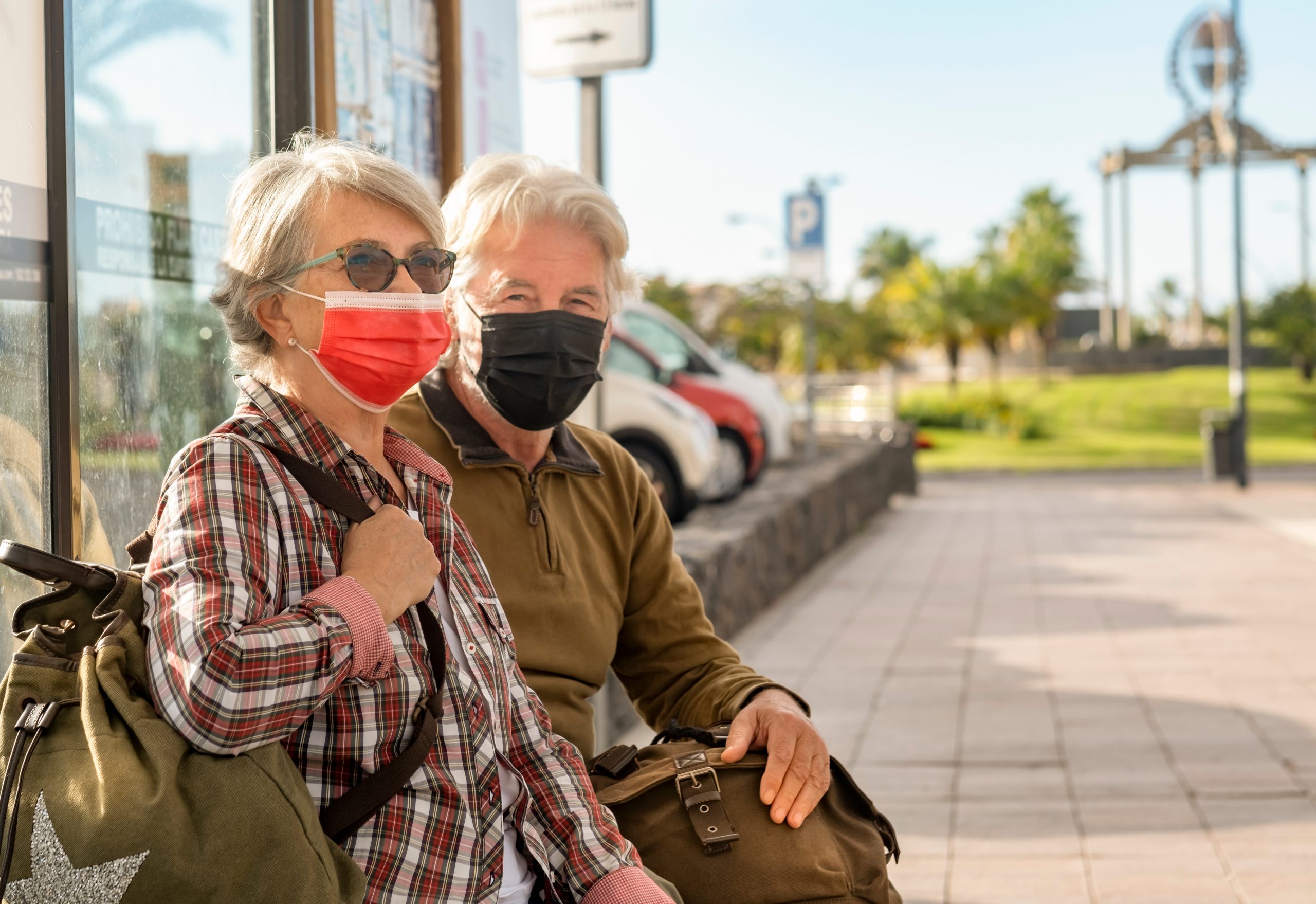 Elderly people waiting for a bus   wearing COVID mask