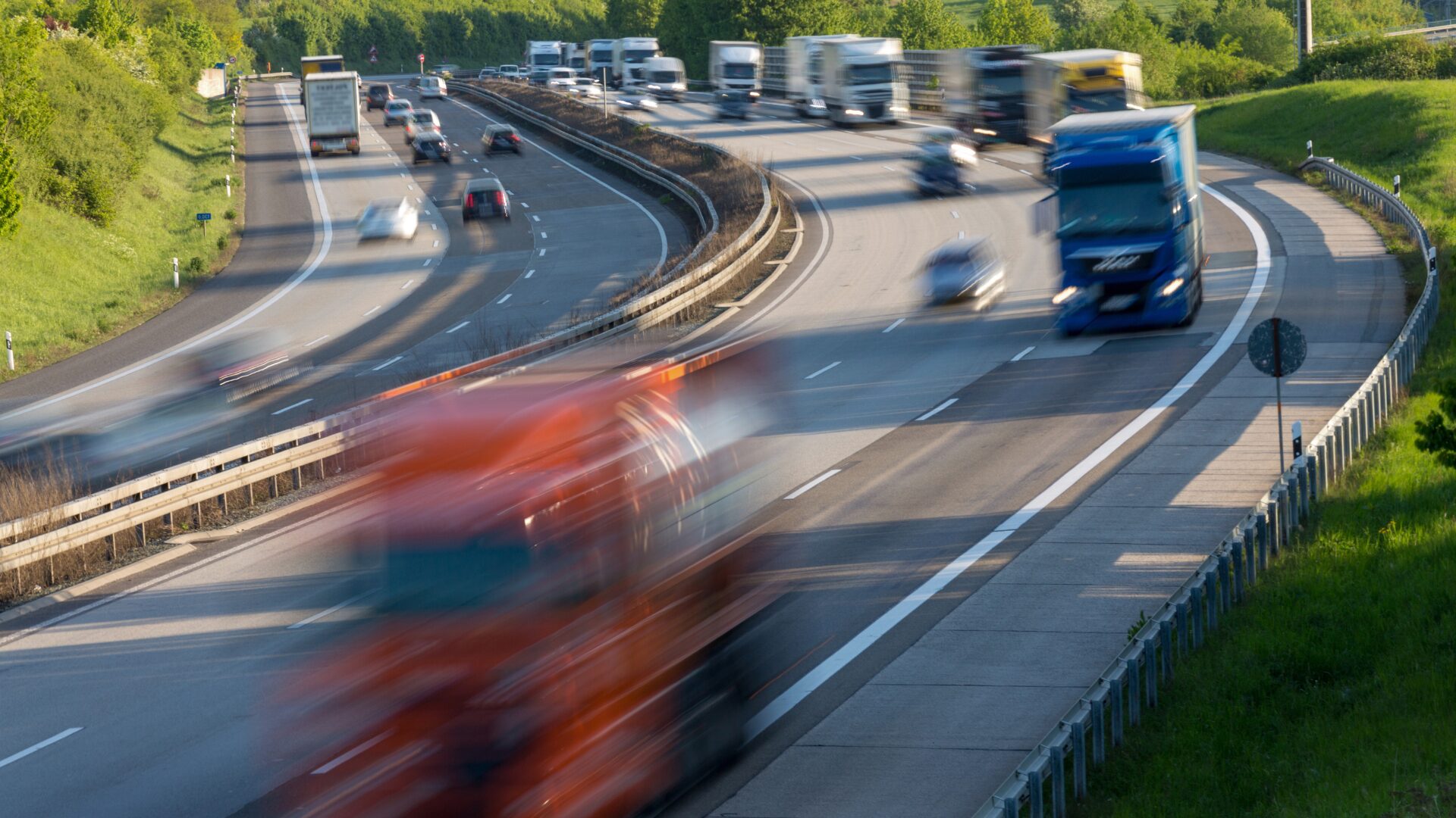 Motorway with trucks driving, symbolising professional driving and transport industry.