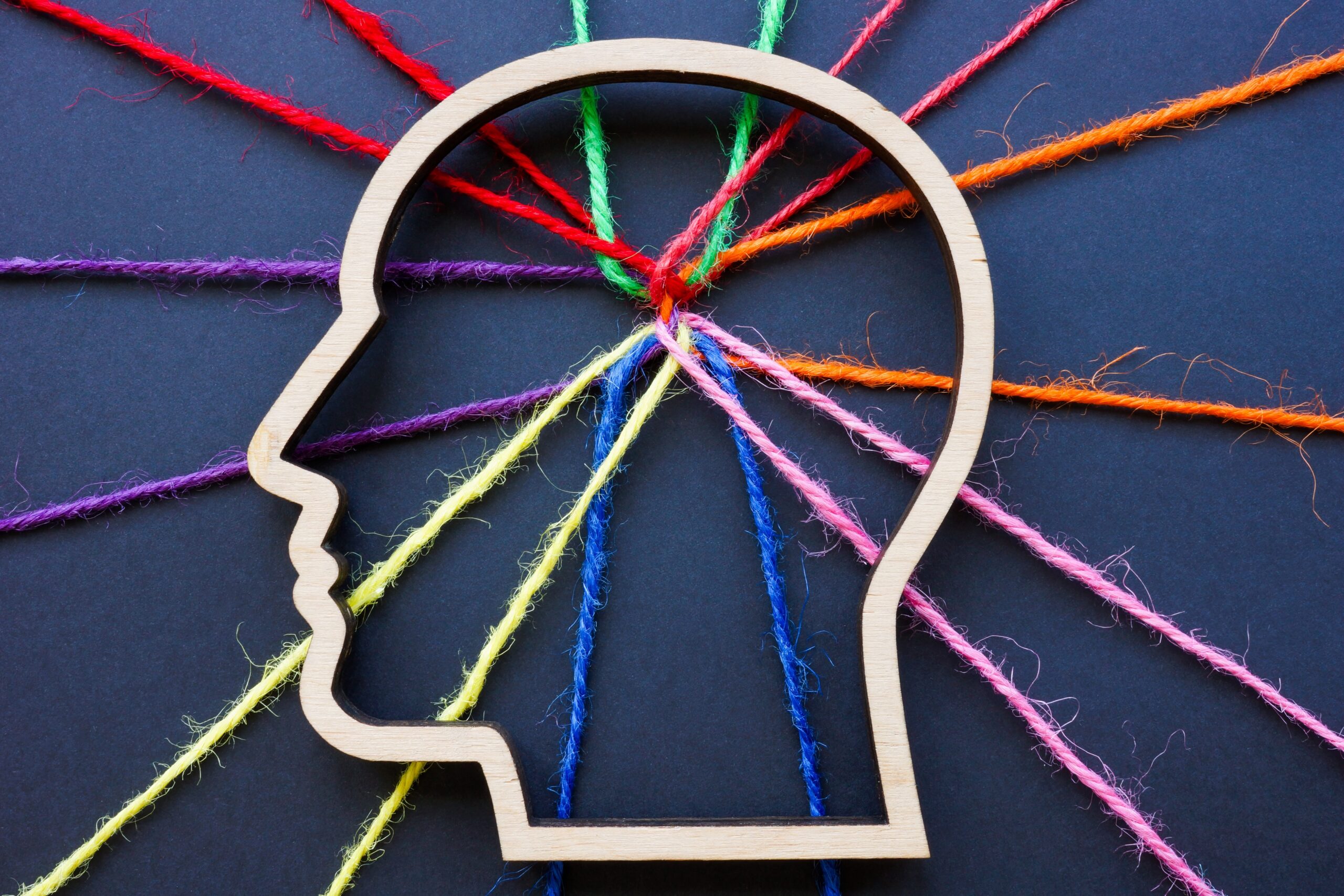 Neurodiversity symbolised by colourful strings entering and exiting a head, representing diverse thought processes and inclusivity in the workplace.