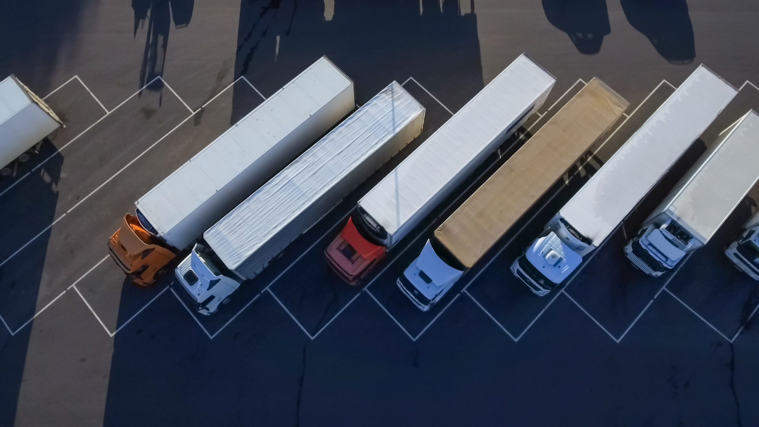 Aerial Top View of White Semi Truck with Cargo Trailer Parking with Other Trucks on Special Parking Lot