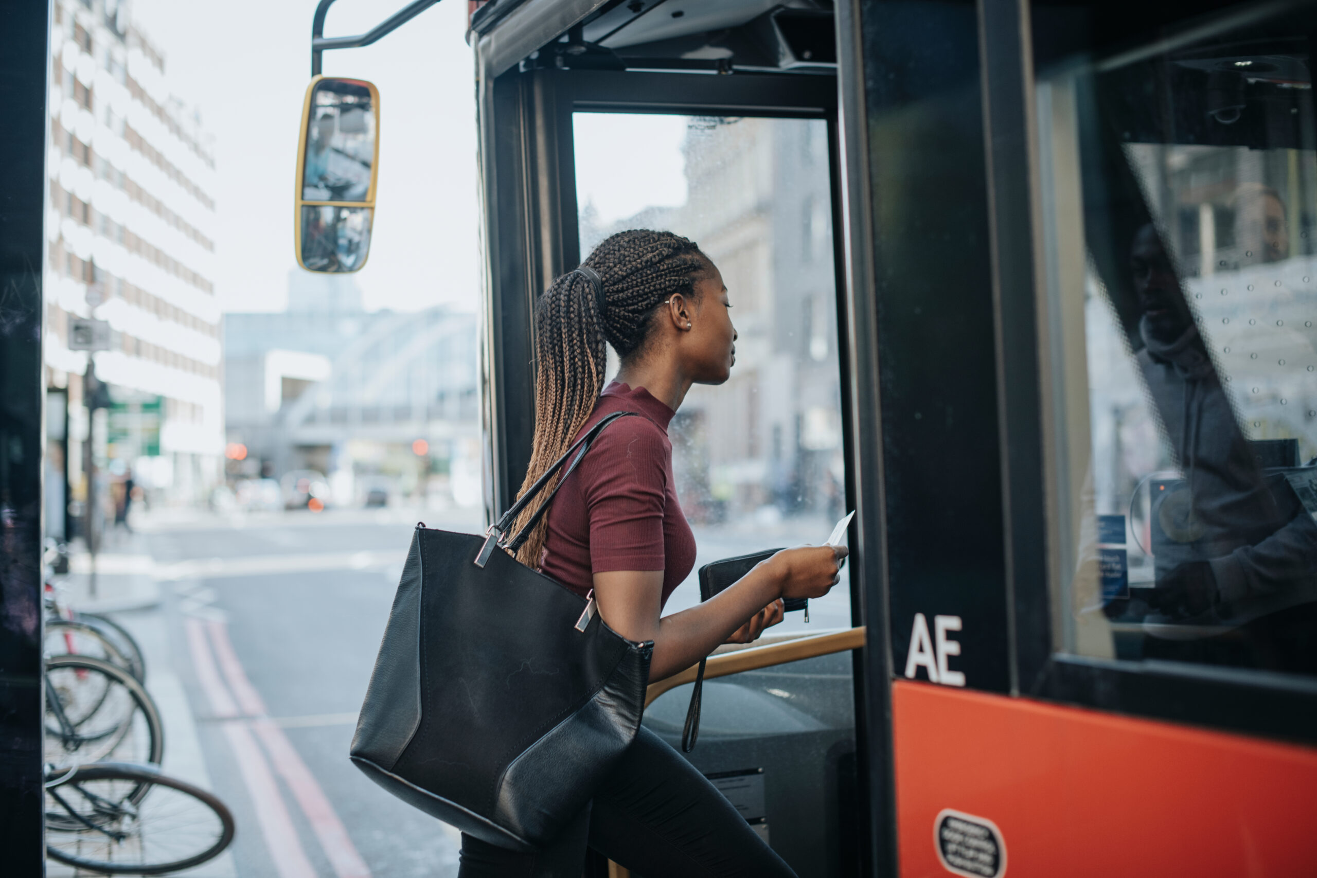 A local bus arriving at a city centre stop with a passenger getting on board.