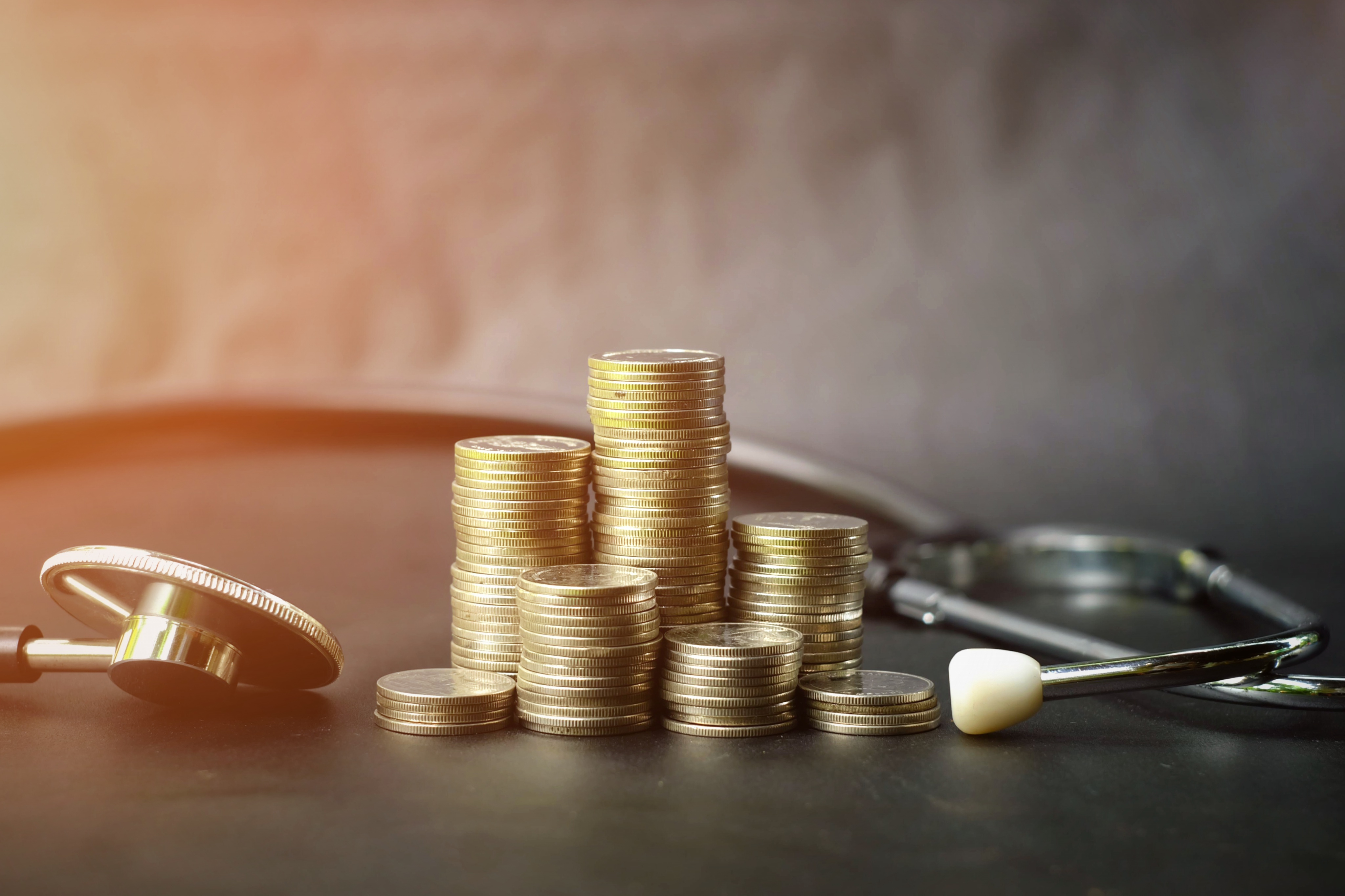 Coins placed next to a stethoscope.