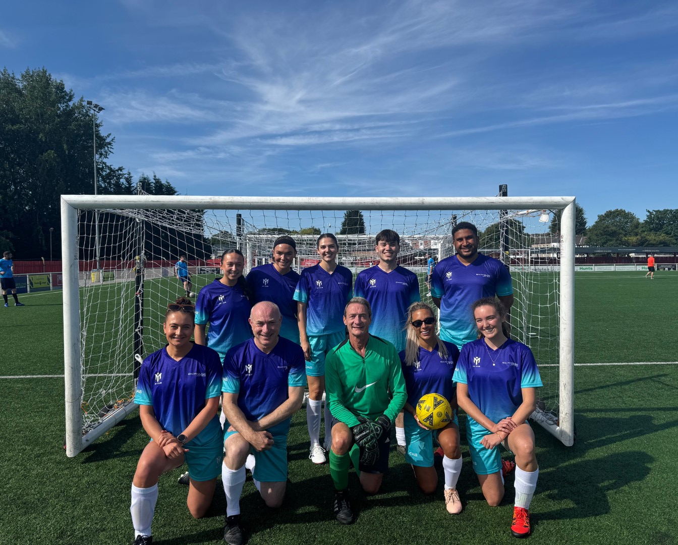 A group photo of the Backhouse Jones football team in kit at the Transaid Cup 2025 charity tournament, Ilkeston Town FC.