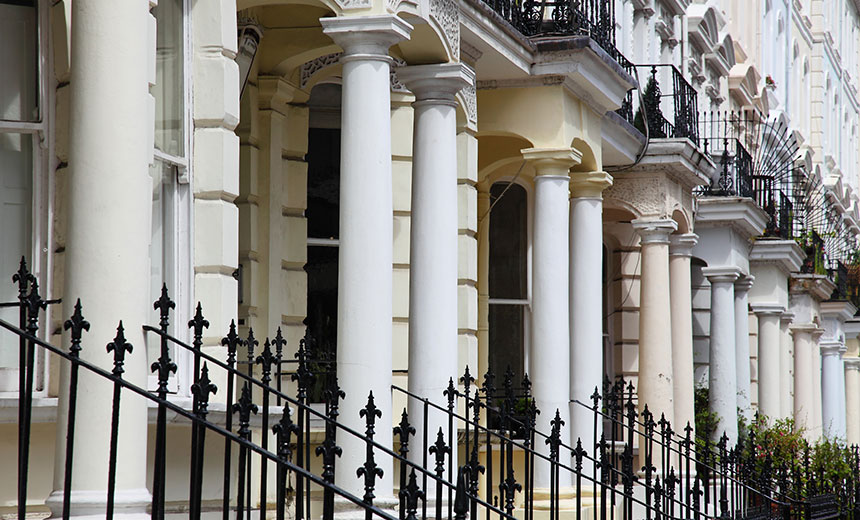 Victorian-style terraced houses with cream façades, white columns, and black iron railings