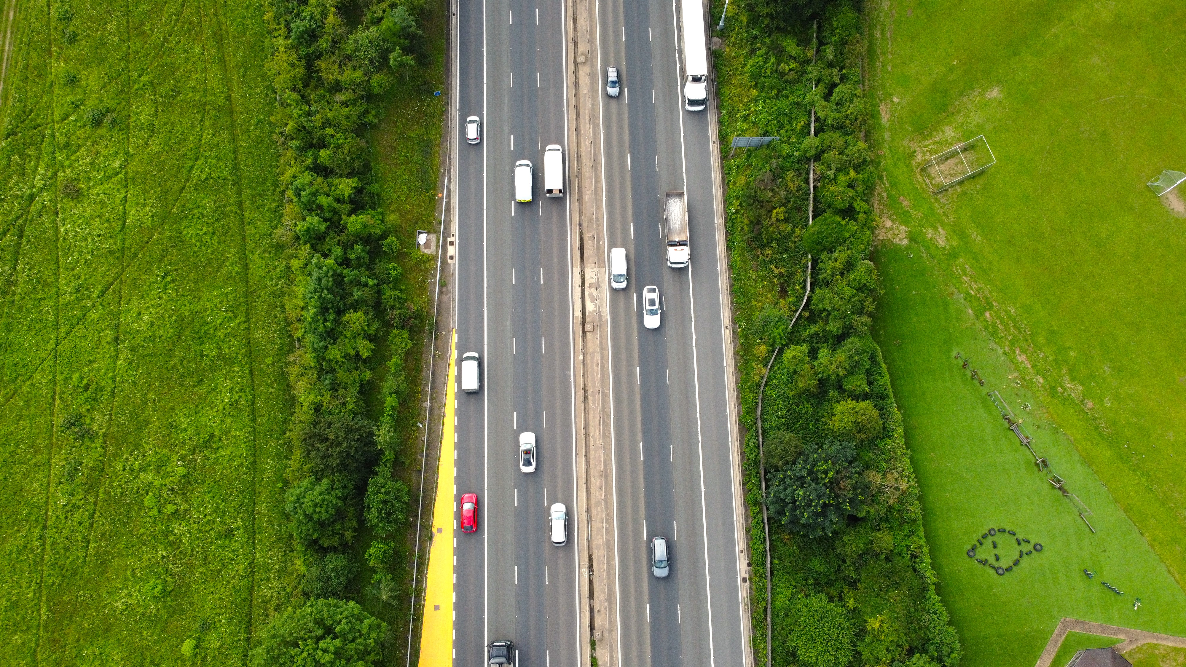 Bird’s-eye view of a UK motorway surrounded by green fields, representing the transport sector and the Traffic Commissioners’ Annual Report.