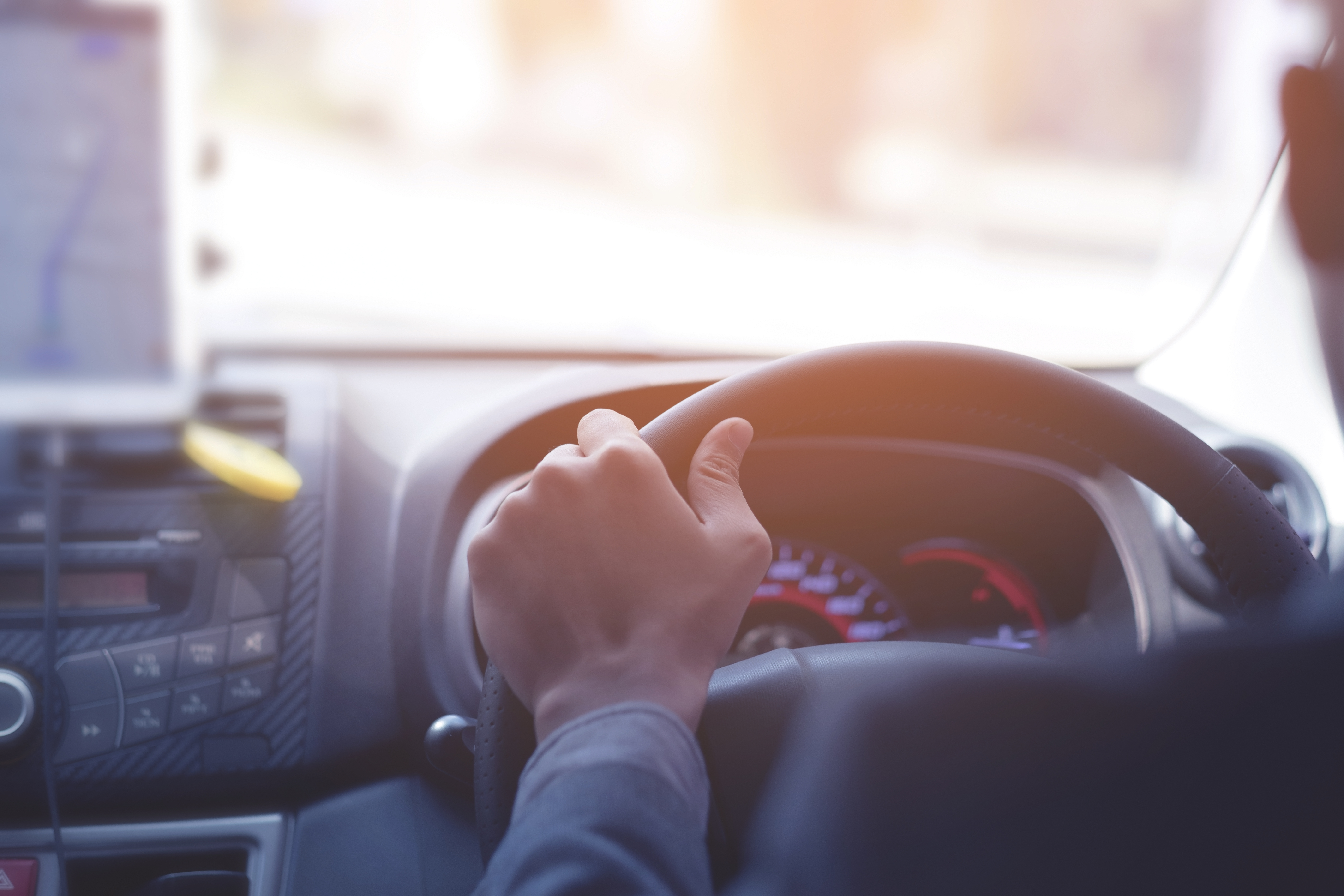 Hands on steering wheel representing travel time and working hours for zero-hours workers