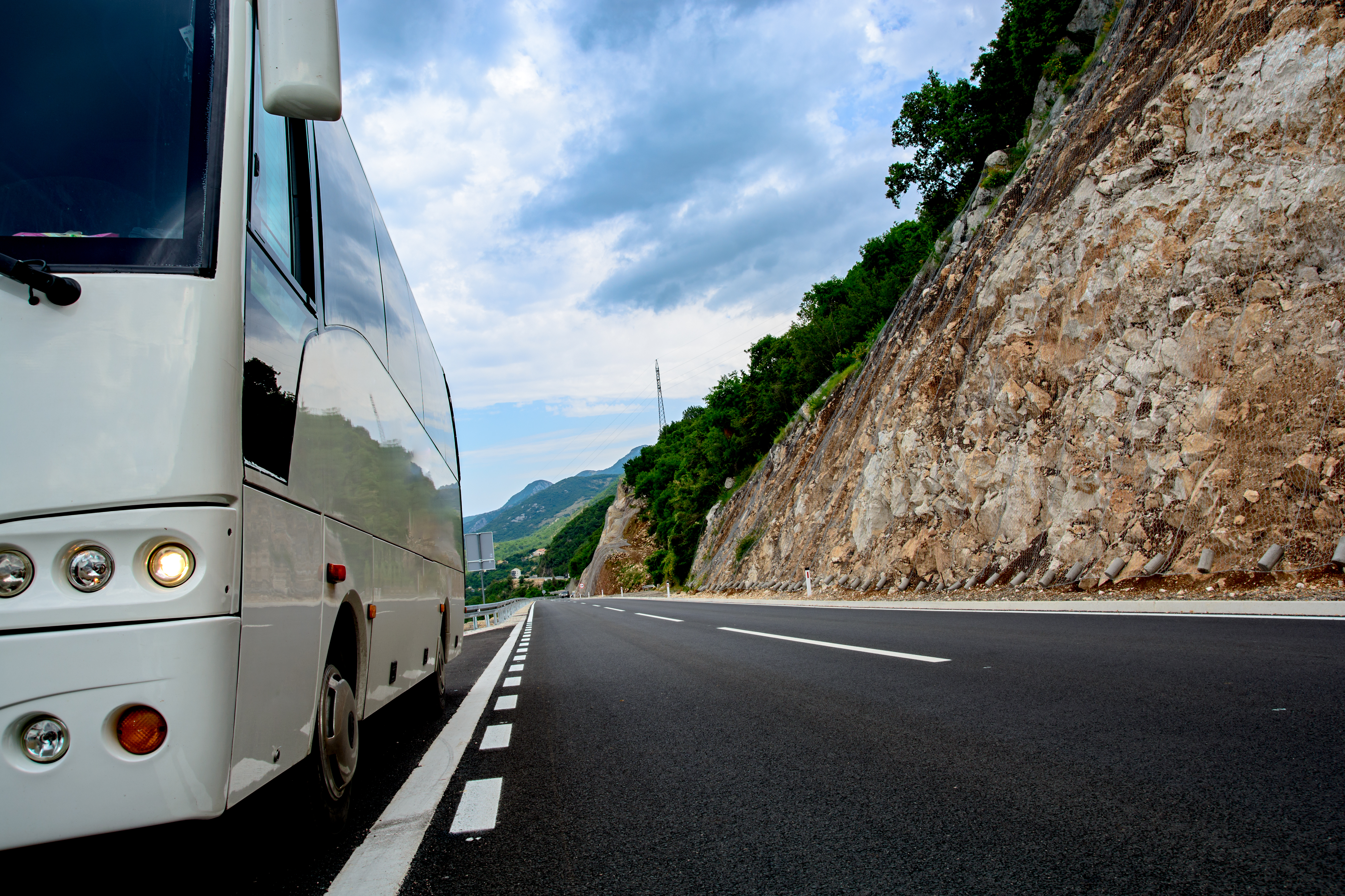 Coach driving on an open road, representing professional bus and coach driver training and DVSA guidance.