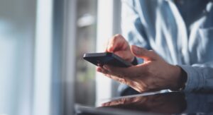 Employee reading workplace WhatsApp messages on a smartphone during an employment dispute.